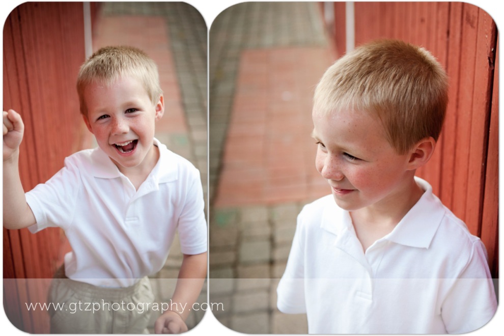 little boy portraits in front of red barn wall